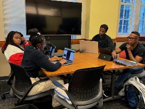 Groups of students work on database activity code academy